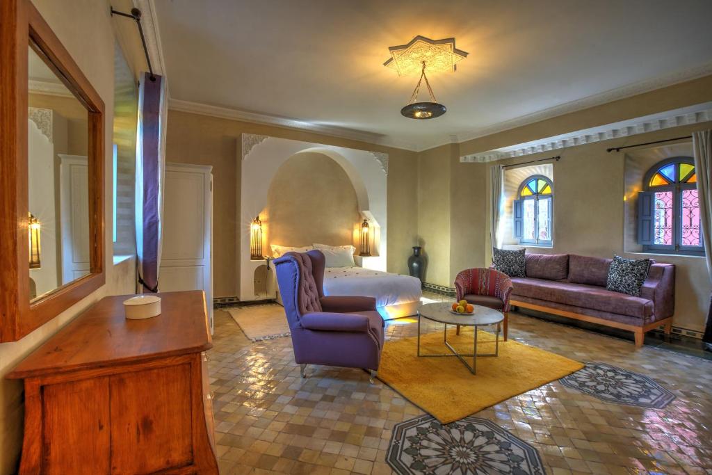 a living room with a bed and a couch and a table at Ksar Anika Boutique Hotel & Spa in Marrakech
