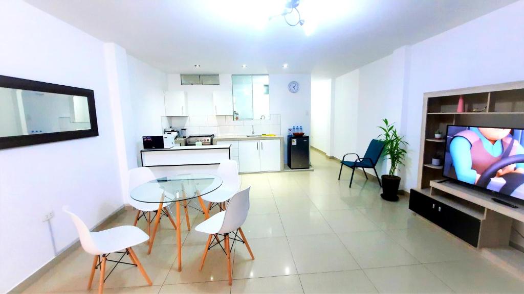 a living room with a table and chairs and a television at Departamento en Pacasmayo in Pacasmayo