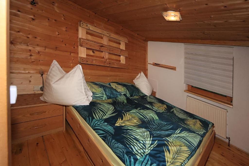 ein Schlafzimmer mit einem Bett in einem Holzzimmer in der Unterkunft Kuanerhof Wohnung 2-4 Personen in Ried im Zillertal