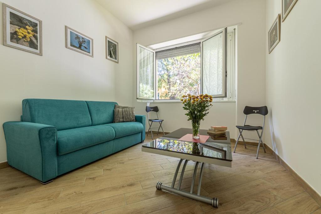 a living room with a blue couch and a table at CityLife, Fiera City, MiCo & San Siro Apartment in Milan