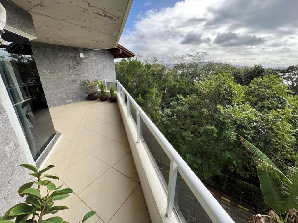 a balcony of a house with a view of trees at Refúgio da Lagoinha - Centro de Bombinhas in Bombinhas