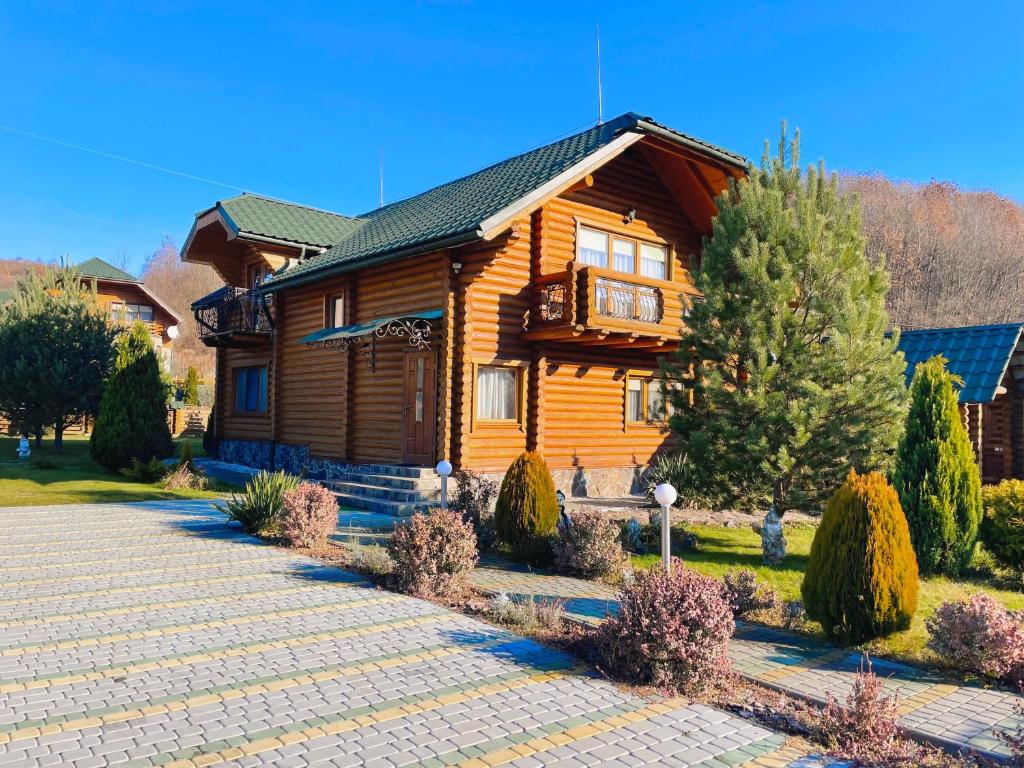 ein Holzhaus mit einem Weg davor in der Unterkunft Сонячний Лаз in Poljana