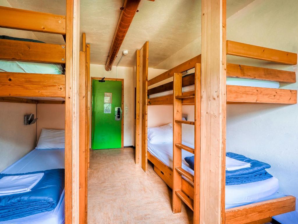 a room with three bunk beds in a cabin at Auberge de Jeunesse HI Chamonix in Chamonix-Mont-Blanc