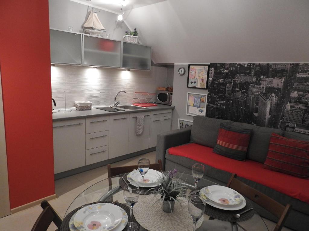 a kitchen and a living room with a couch and a table at apartament Jaśkowy in Żarnowska