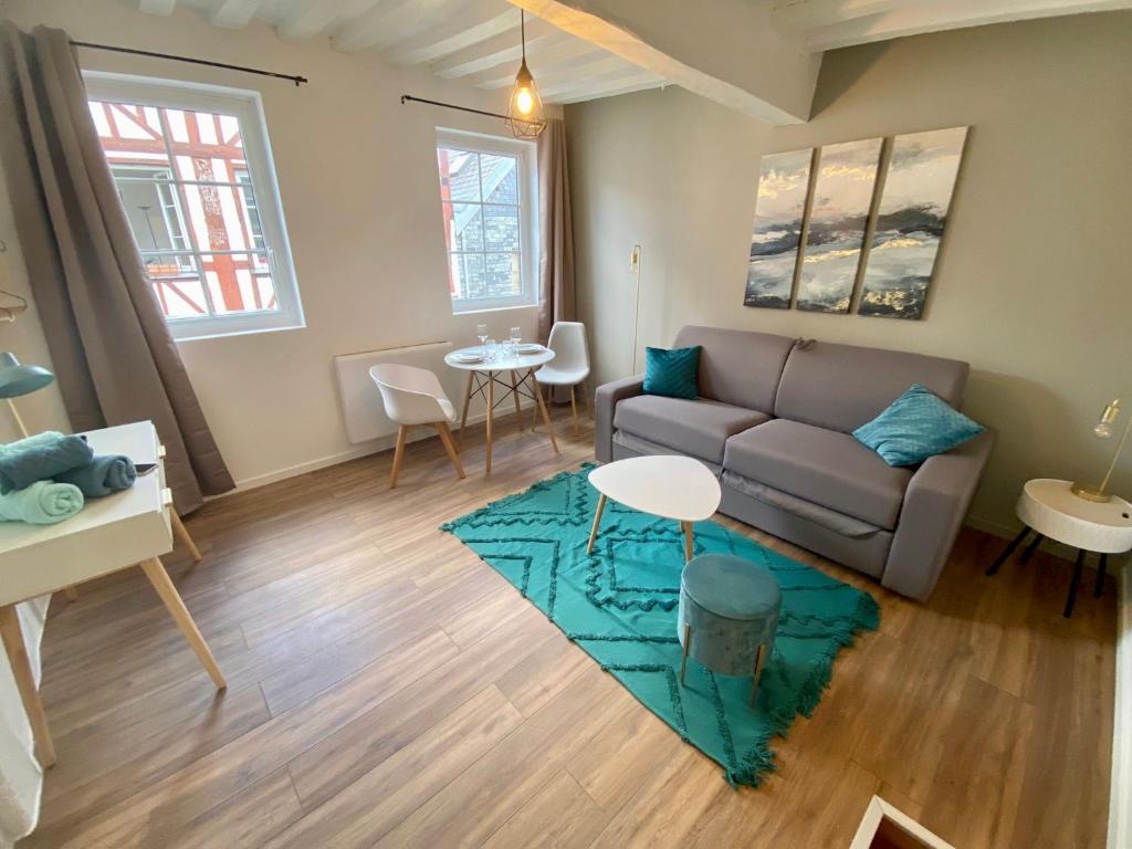 ein Wohnzimmer mit einem Sofa und einem Tisch in der Unterkunft Le studio bleu - studio hypercentre Rouen - 106 in Rouen