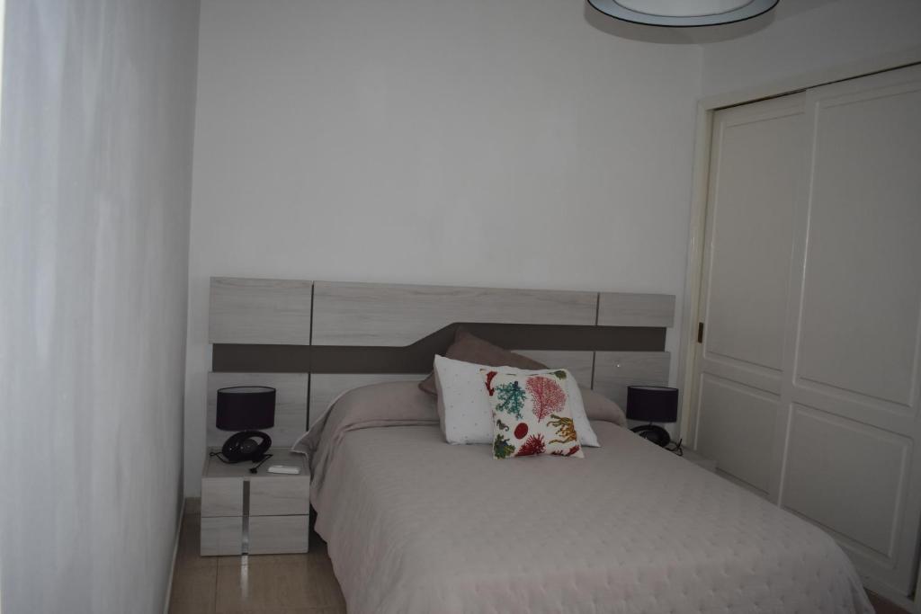 sypialnia z białym łóżkiem z 2 lampami i 2 poduszkami w obiekcie El Quijote with private heated pool w mieście San Bartolomé