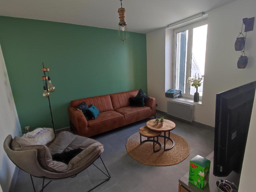 a living room with a couch and a tv at Nancy - Maison chaleureuse in Champigneulles