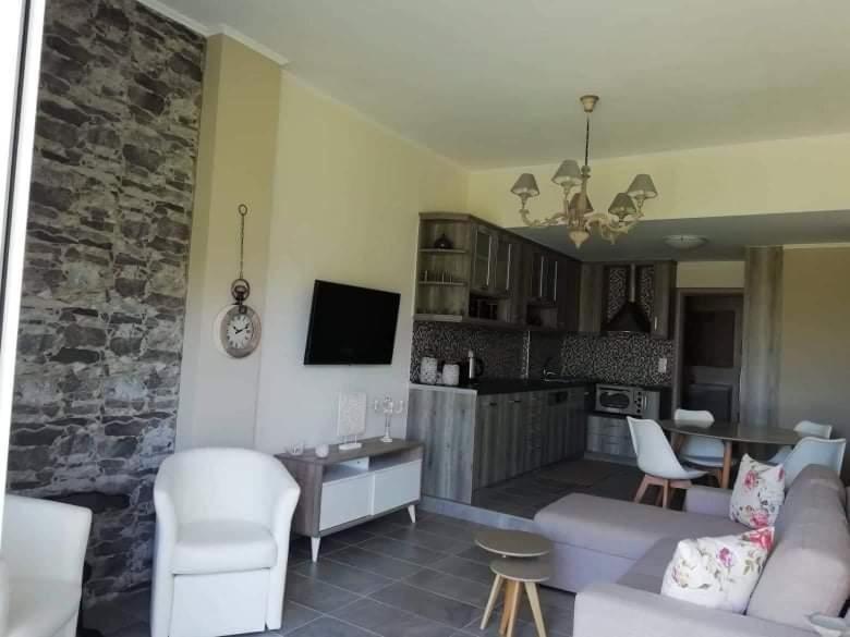 a living room with a white couch and a kitchen at HOTEL LOFOS APARTMENT in Plakias