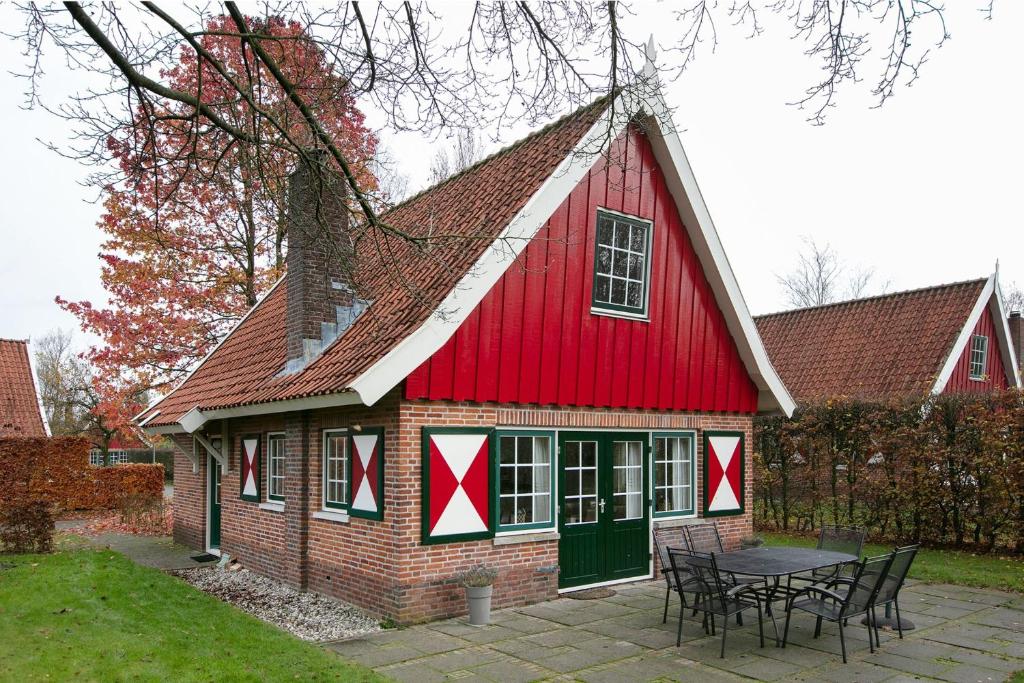 eine rote Scheune mit einem Tisch davor in der Unterkunft Vakantiehuis Schanszicht in Lievelde