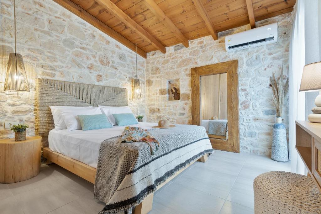 een slaapkamer met een bed en een stenen muur bij The Violin House in Chania