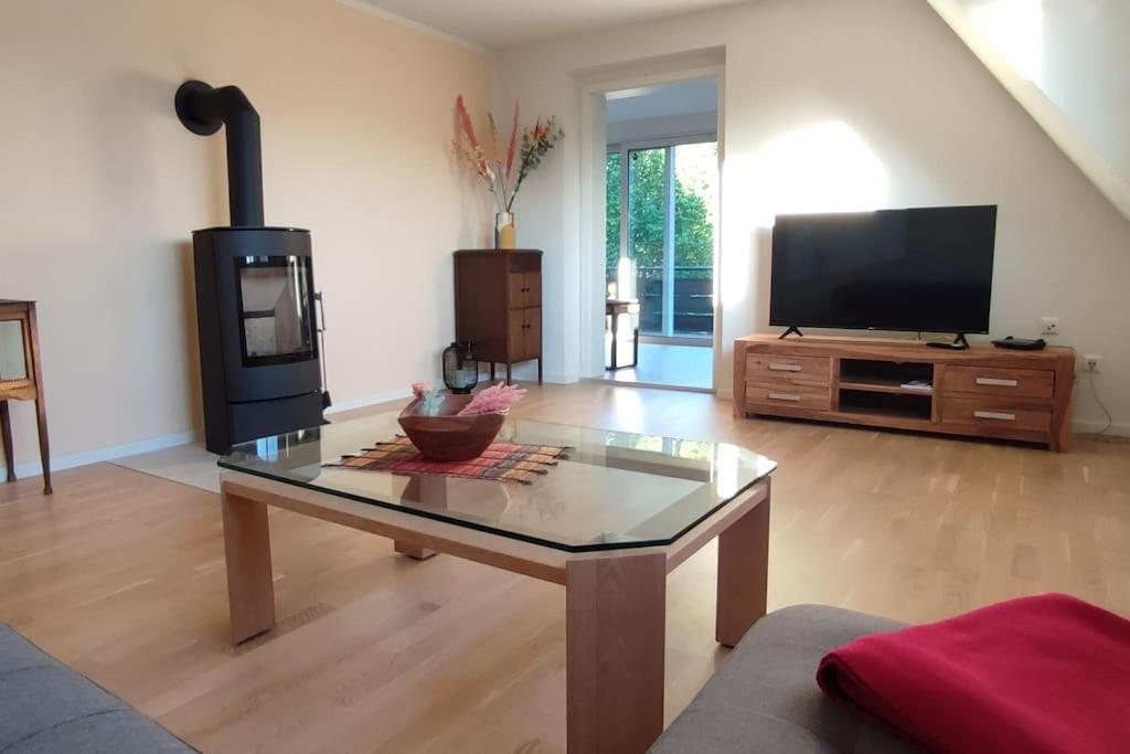 sala de estar con mesa de centro y TV de pantalla plana en Top Ferienwohnung am Waldrand mit großem Balkon, en Lübbecke