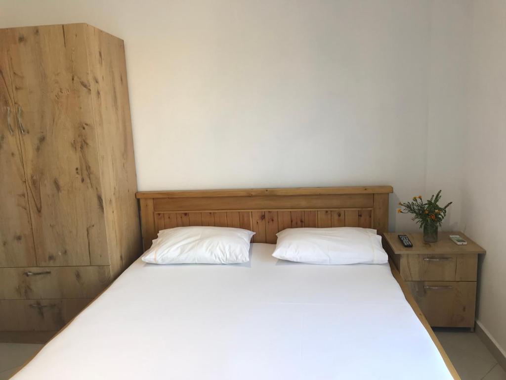 a bedroom with a bed with two pillows on it at Vila Bedro in Sarandë