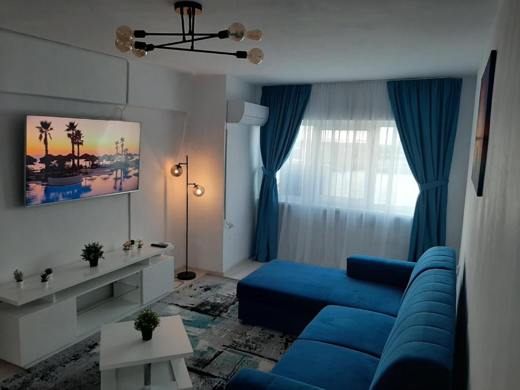 a living room with a blue couch and a window at Apartament DeltaView Deluxe Sulina in Sulina