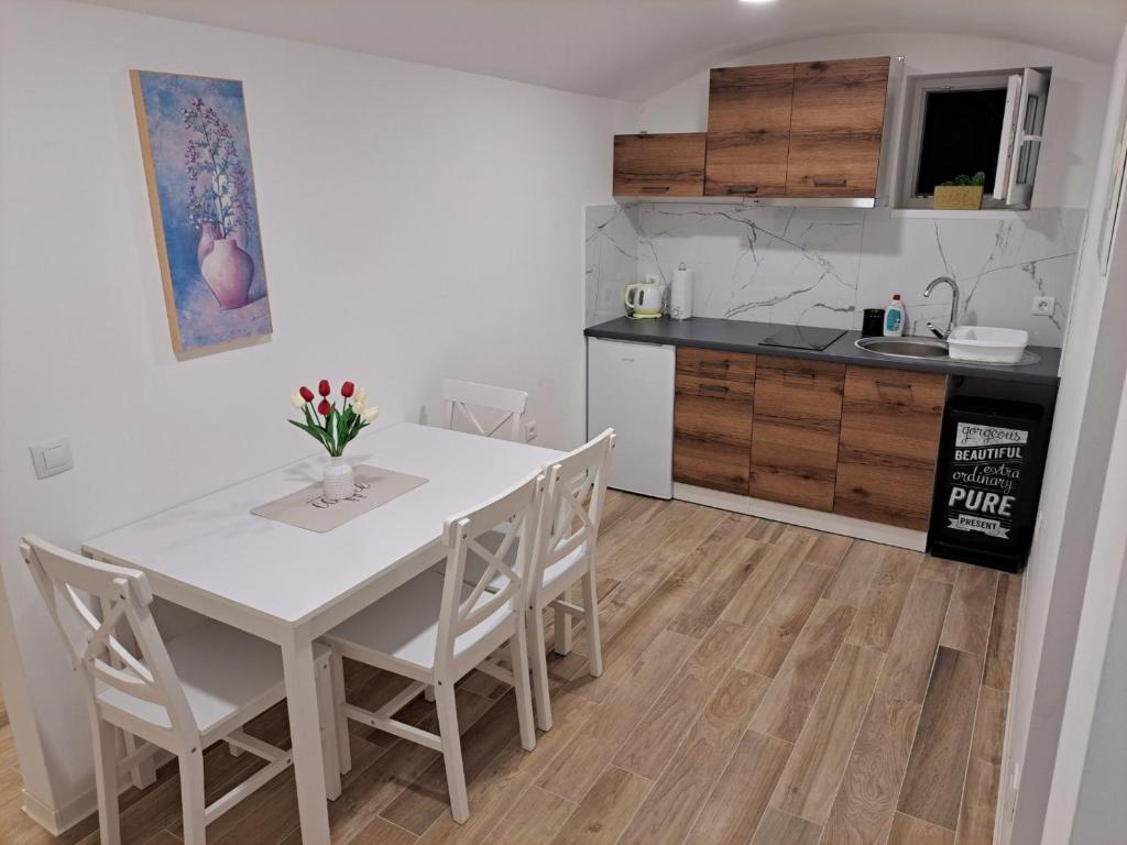 a kitchen and dining room with a white table and chairs at Apartment DINLUX in Maribor