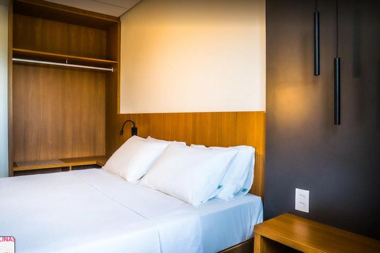 een groot bed met witte kussens in een kamer bij Apartamento Salinas Premium Resort in Salinópolis