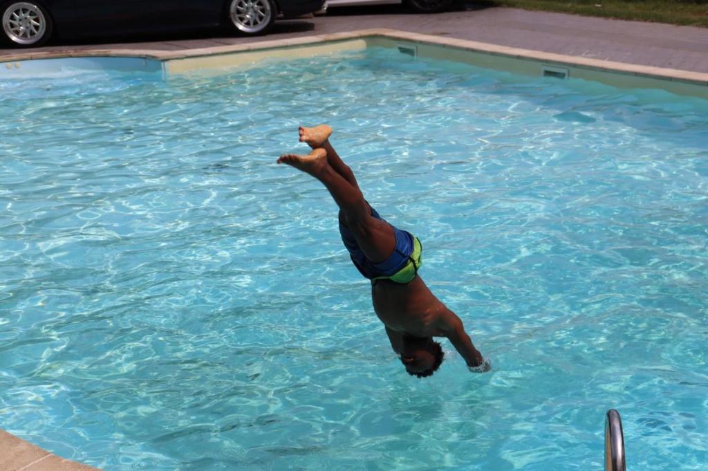 een man duikt in een zwembad in een zwembad bij Hotel Mirabeau in Bellagio