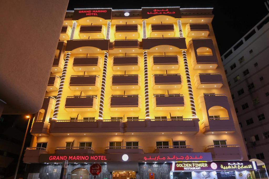 a tall yellow building with lots of windows at Grand Marino Hotel in Dubai