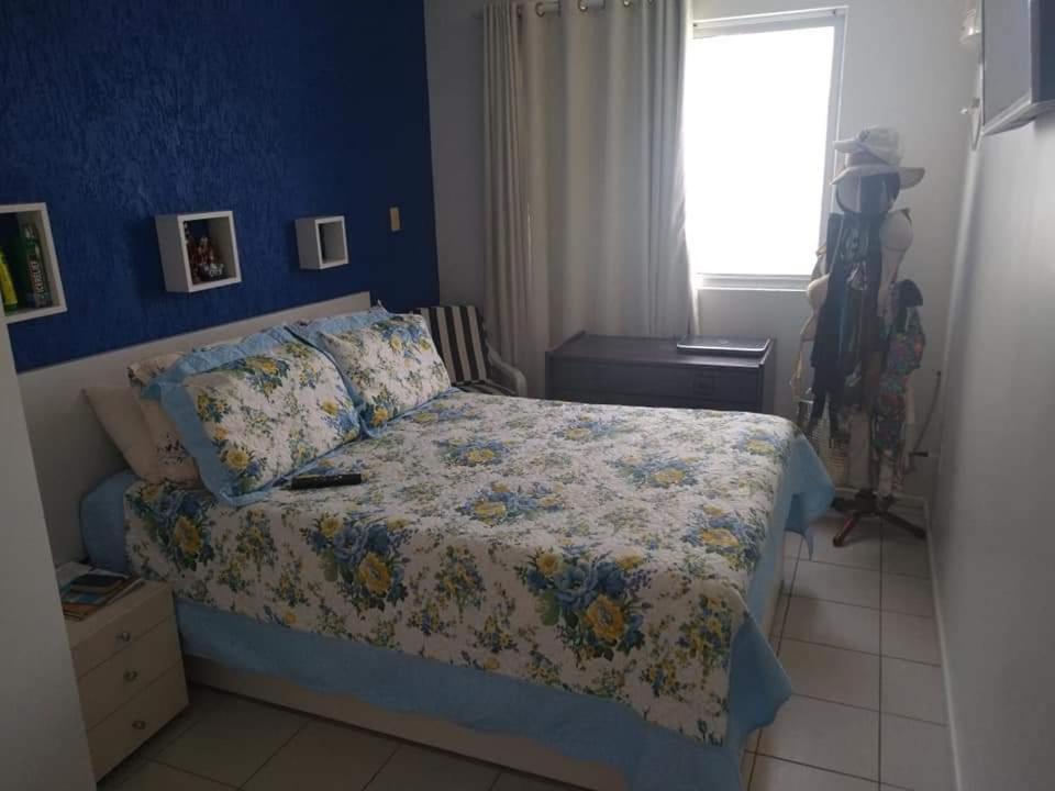 1 dormitorio con cama y pared azul en Refúgio Esmeralda en Guarajuba