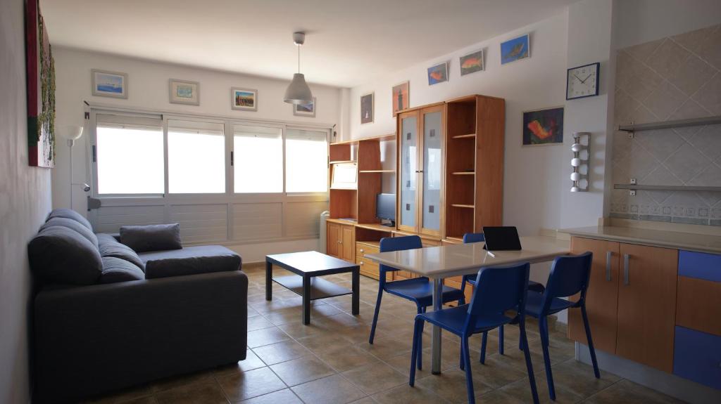 uma sala de estar com um sofá, uma mesa e cadeiras em Apartamento en La Caleta El Hierro em Valverde