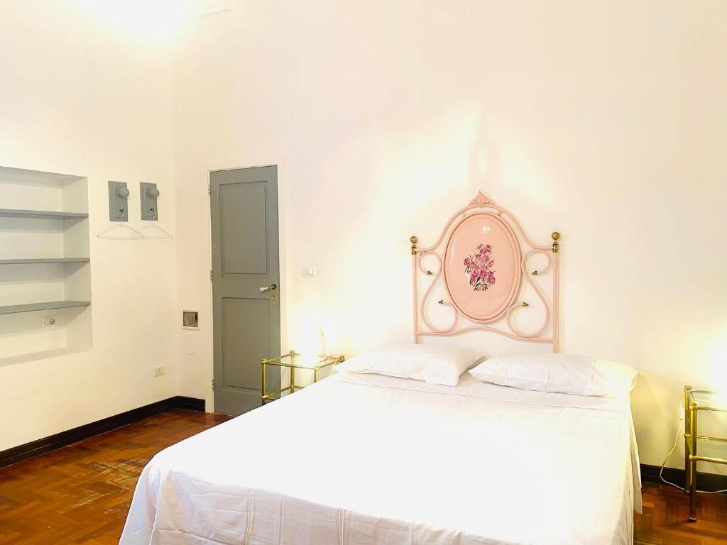 a bedroom with a white bed with a pink headboard at PALAZZO PORCARI in Lecce