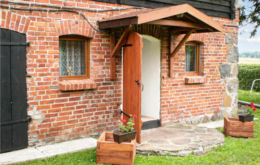 a brick house with a door and some flowers at Gorgeous Apartment In Retowo 4 With Kitchen in Gardna Wielka