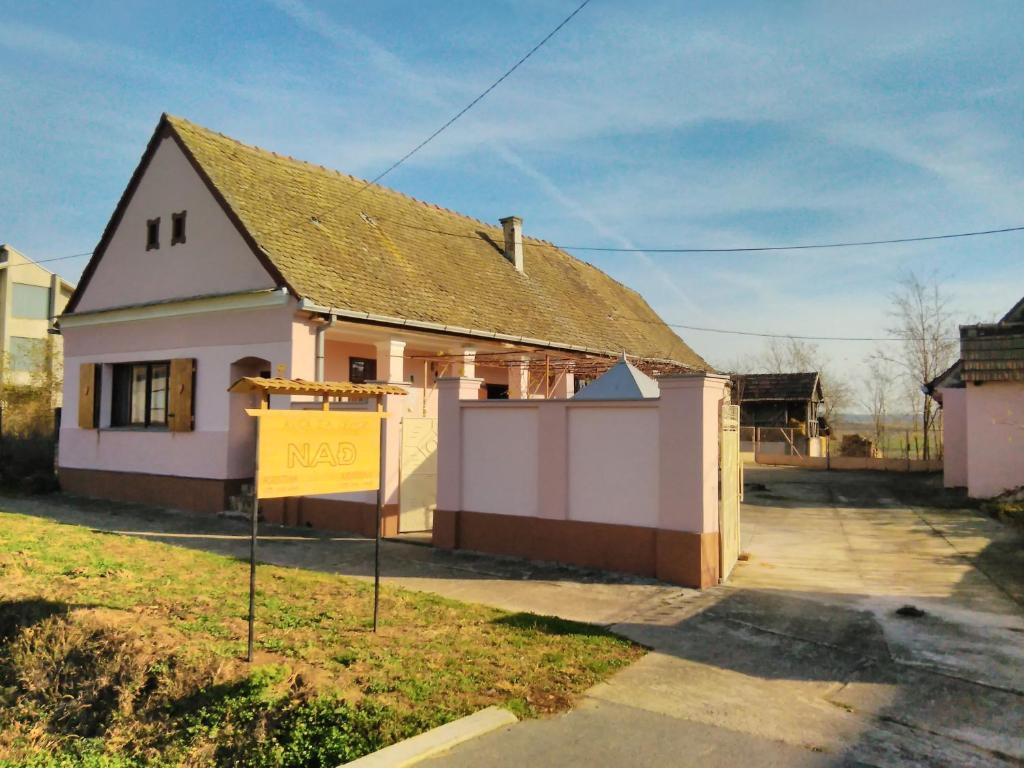 a house with a yellow sign in front of it at Holiday house with a parking space Orolik, Slavonija - 14358 in Privlaka