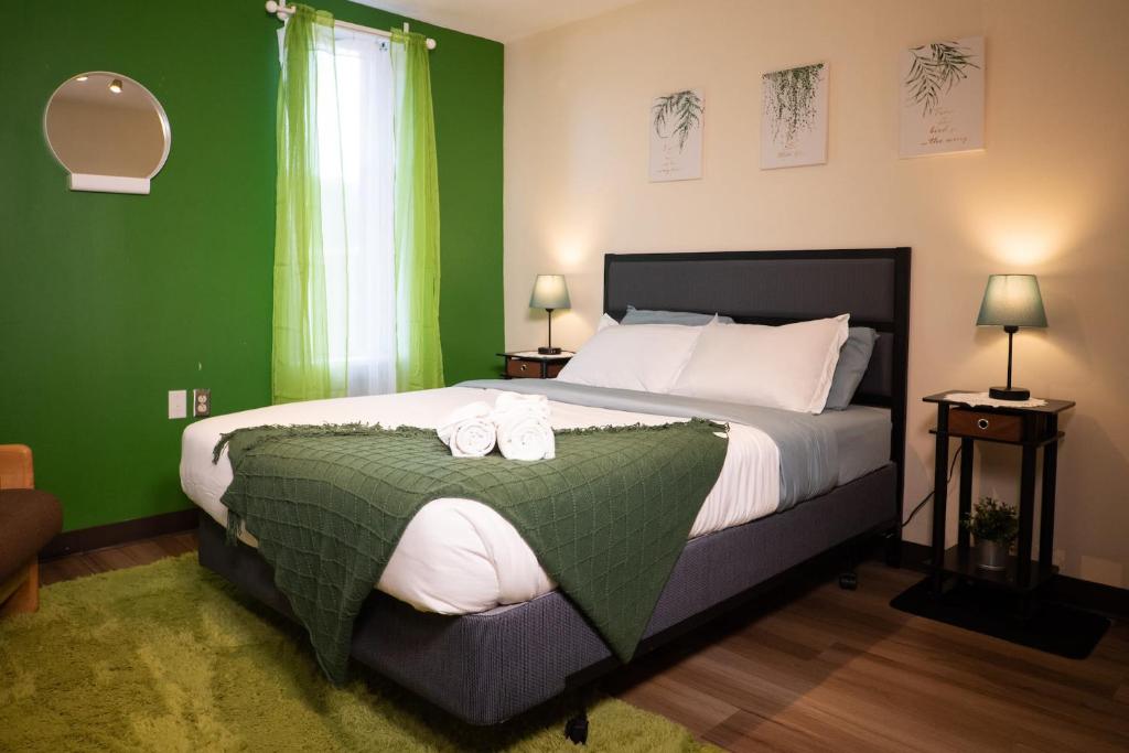 a bedroom with a large bed with green walls at Stay Pittsburgh in Pittsburgh