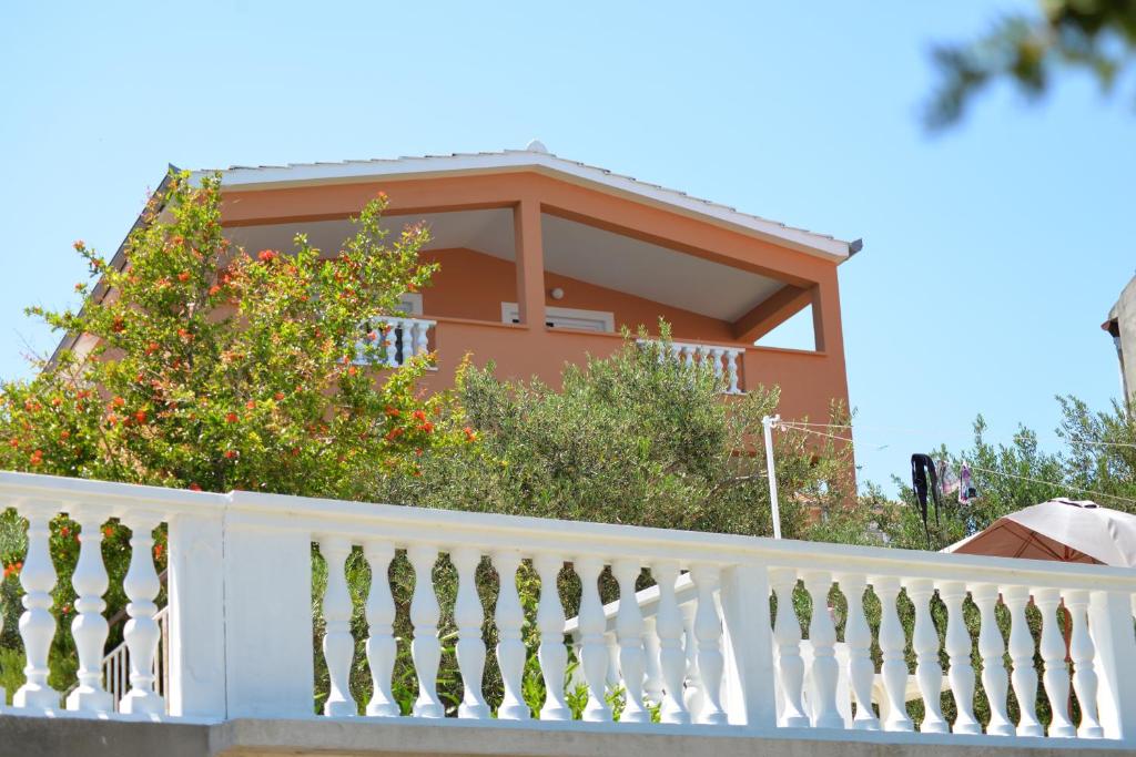 una casa con una recinzione bianca e alberi di Apartments by the sea Tkon, Pasman - 16589 a Tkon (Tuconio)