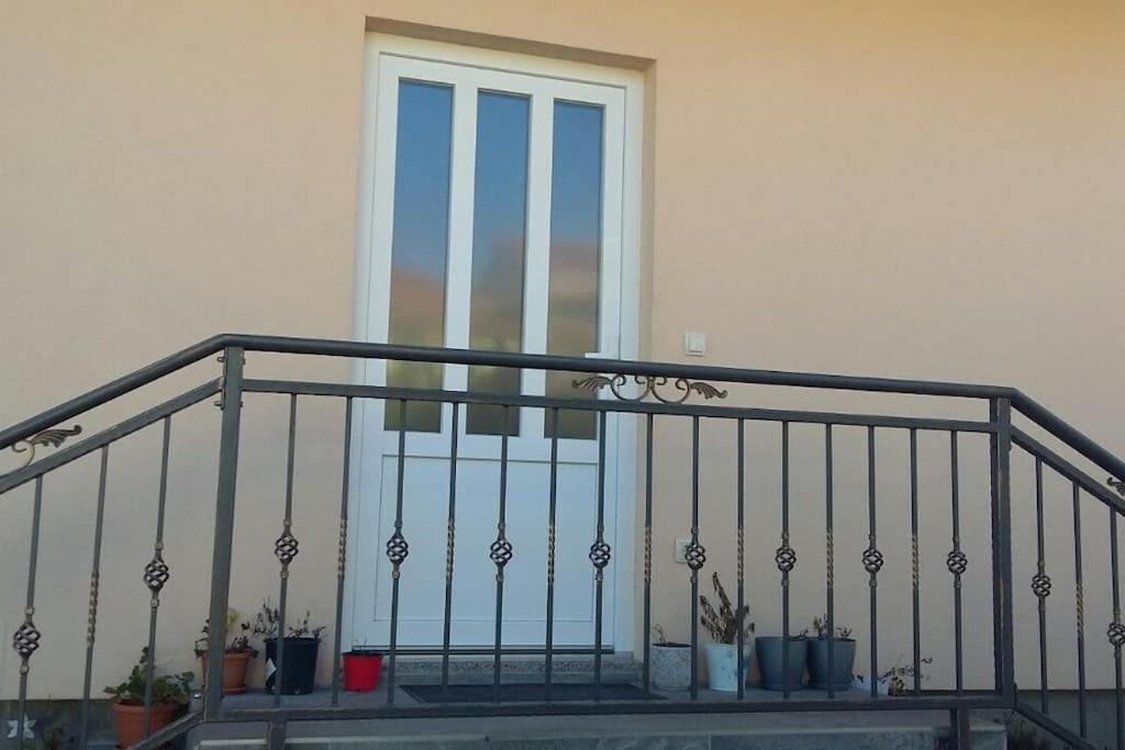 a balcony with potted plants in front of a window at Seaside holiday house Trpanj, Peljesac - 16703 in Trpanj