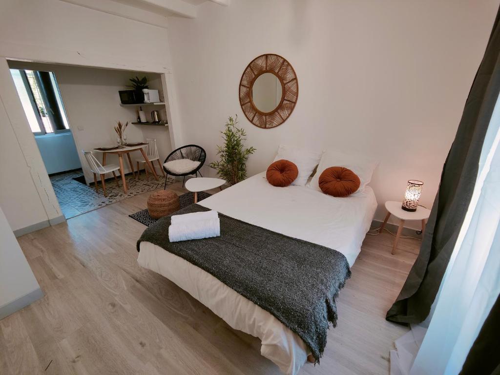 ein Schlafzimmer mit einem großen weißen Bett und einem Tisch in der Unterkunft Studio cozy proche de Paris in Colombes