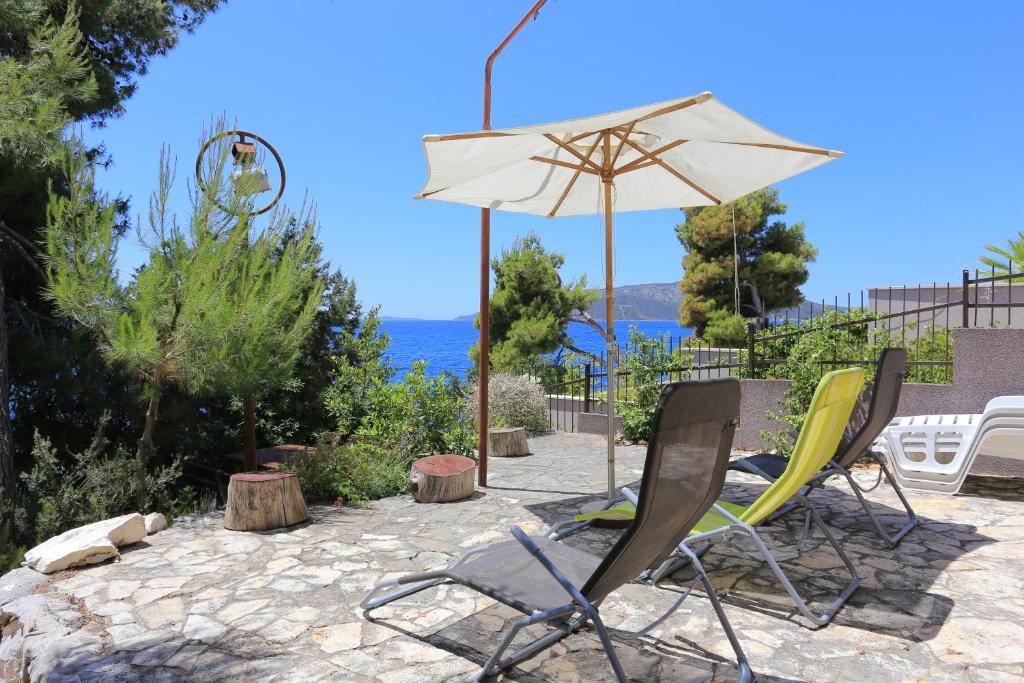 a patio with two chairs and an umbrella at Apartment Okrug Donji 16657b in Okrug Donji