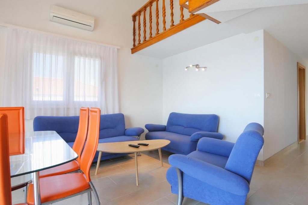 a living room with blue chairs and a table at Apartment Okrug Donji 16657b in Okrug Donji