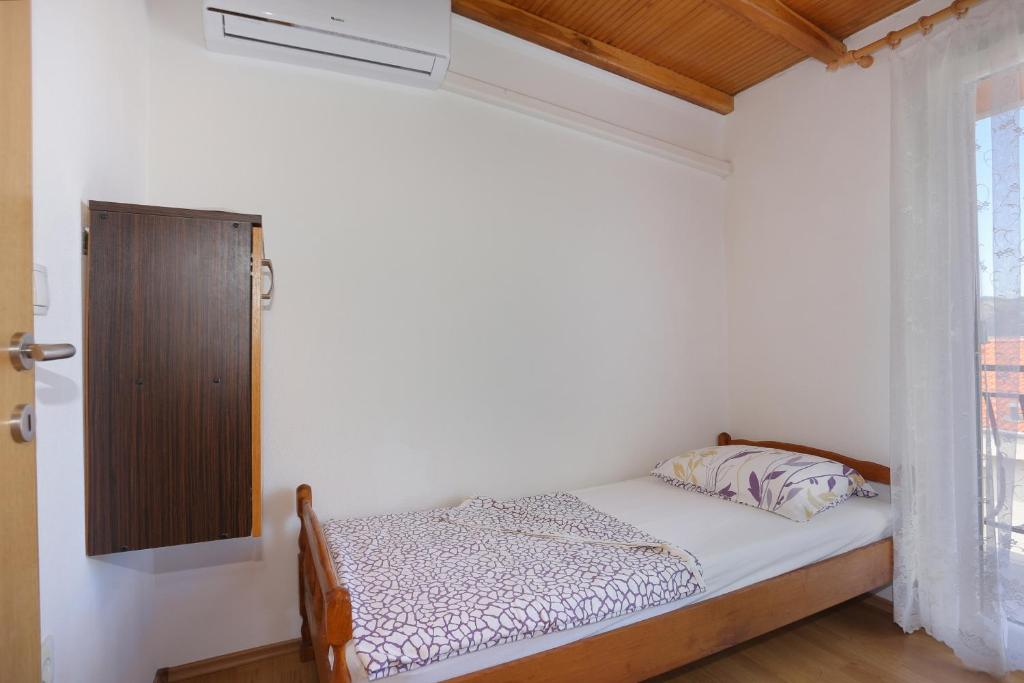 a small bed in a room with a window at Apartment Okrug Donji 16657b in Okrug Donji