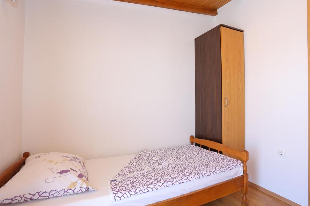 a small bedroom with a bed and a cabinet at Apartment Okrug Donji 16657b in Okrug Donji