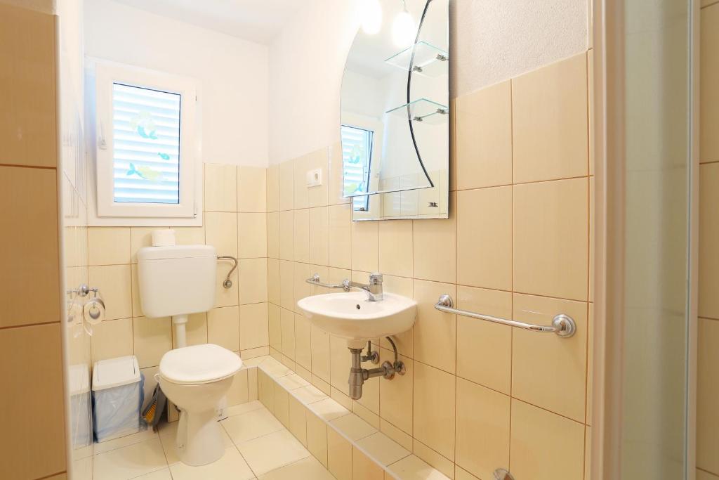 a bathroom with a toilet and a sink and a mirror at Apartment Okrug Donji 16657b in Okrug Donji