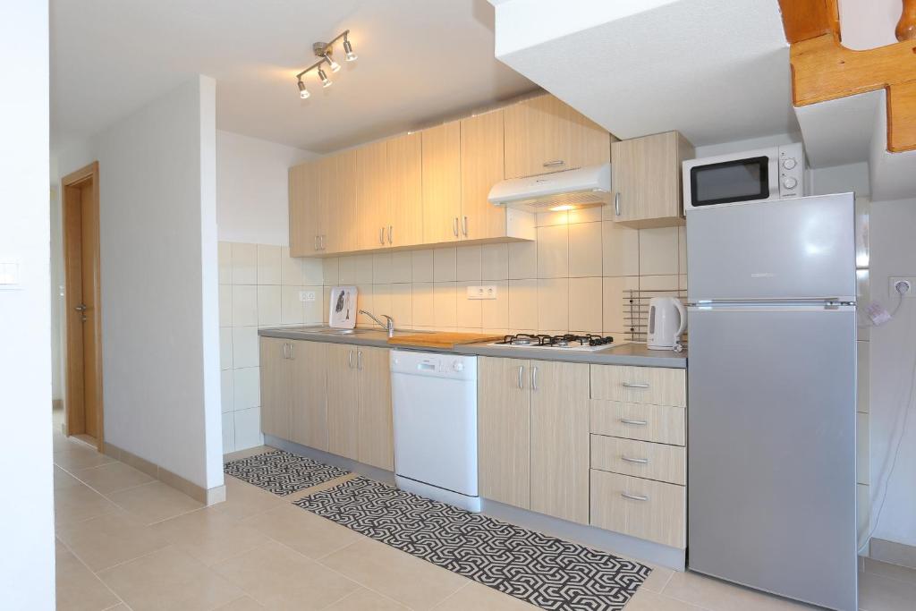 a kitchen with a white refrigerator and cabinets at Apartment Okrug Donji 16657b in Okrug Donji