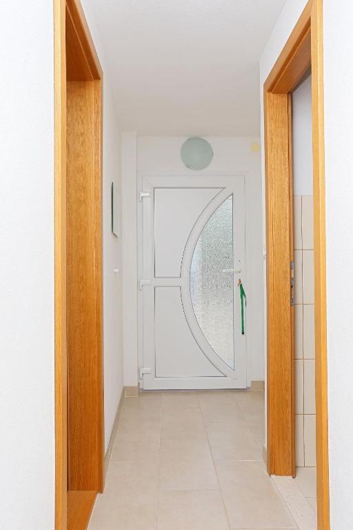a hallway with a white door with a window at Apartment Okrug Donji 16657b in Okrug Donji