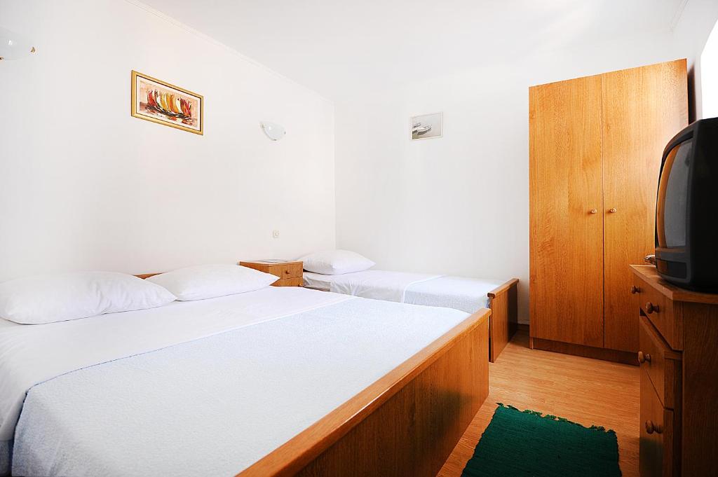 pokój hotelowy z dwoma łóżkami i telewizorem w obiekcie Studio Okrug Donji 16737b w mieście Okrug Donji