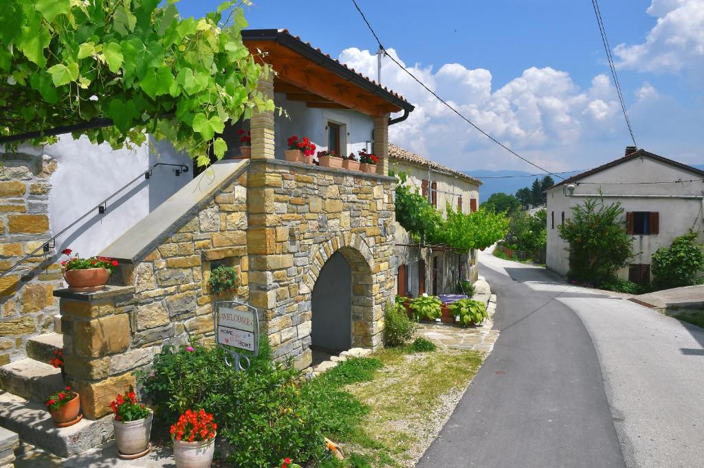 a stone building with flowers on a street at Holiday house with WiFi Paz, Central Istria - Sredisnja Istra - 16623 in Buzet