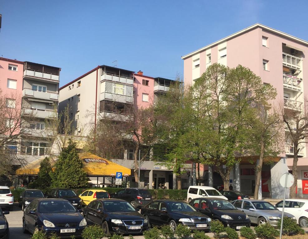 a parking lot with cars parked in front of buildings at Apartments with WiFi Vinkovci, Slavonija - 16805 in Vinkovci