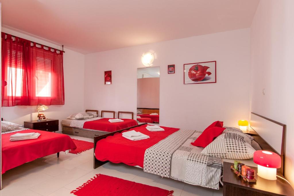 1 dormitorio con 2 camas con sábanas rojas en Apartments by the sea Duce, Omis - 16877, en Dugi Rat