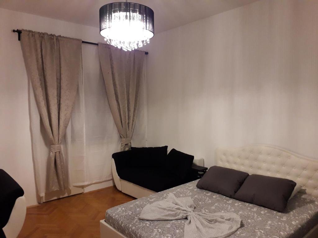 um quarto com uma cama, um sofá e um lustre em Apartments with WiFi Split - 16911 em Split