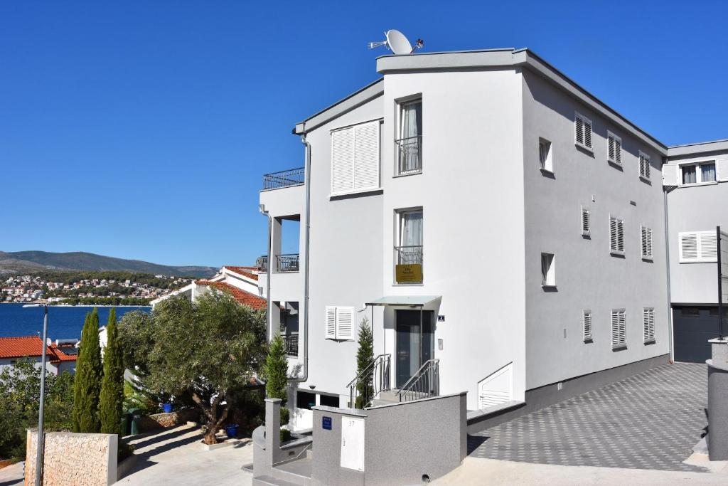 ein weißes Gebäude mit Blick auf das Wasser in der Unterkunft Apartments with a parking space Okrug Gornji, Ciovo - 16935 in Trogir