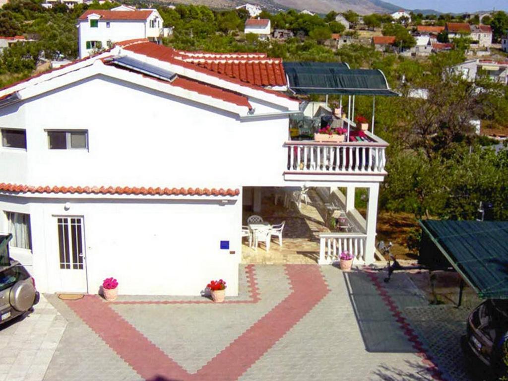 a white house with a balcony on top of it at Apartments by the sea Grebastica, Sibenik - 16767 in Grebaštica