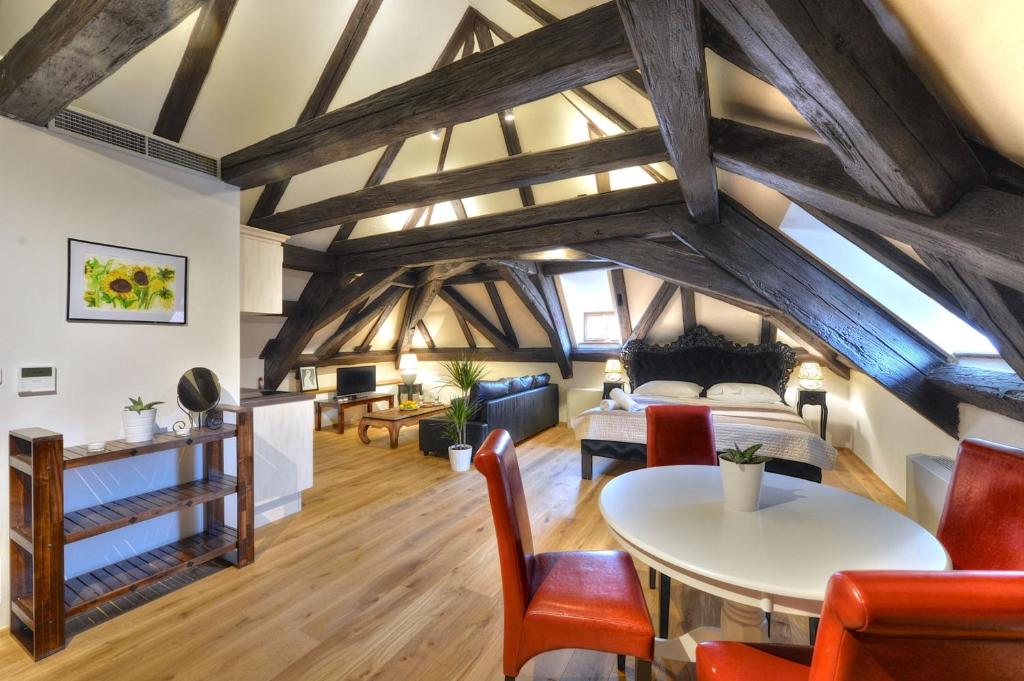 an attic room with a bed and a table and chairs at Old Town Boutique Apartments in Prague