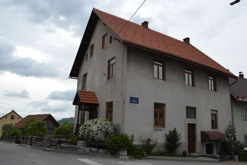 een groot wit huis met een rood dak bij Rooms with a parking space Brod Moravice, Gorski kotar - 16921 in Brod Moravice