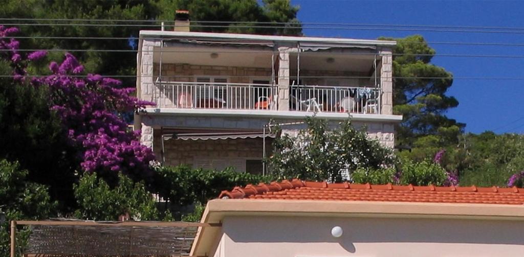 un bâtiment avec un balcon sur le toit dans l'établissement Apartments by the sea Prizba, Korcula - 16900, à Prižba