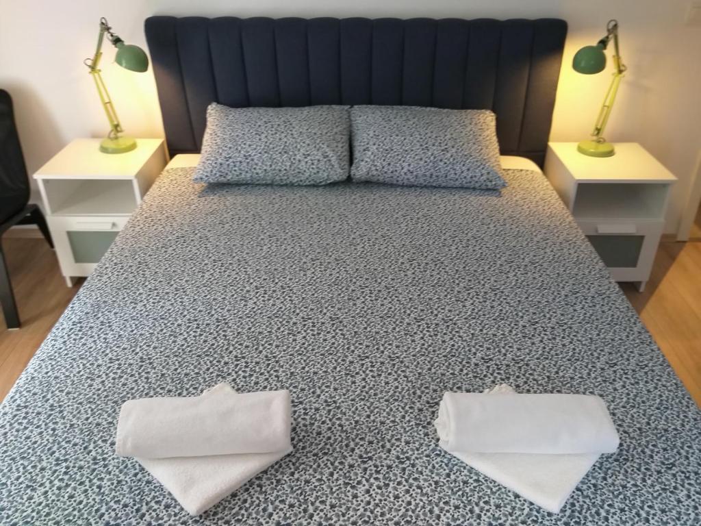a bed with two pillows on it with two lamps at Double Room Njivice 17010a in Njivice