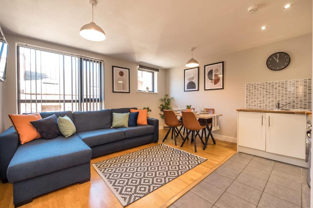 a living room with a blue couch and a kitchen at Host & Stay - Ropewalks Apartment in Liverpool