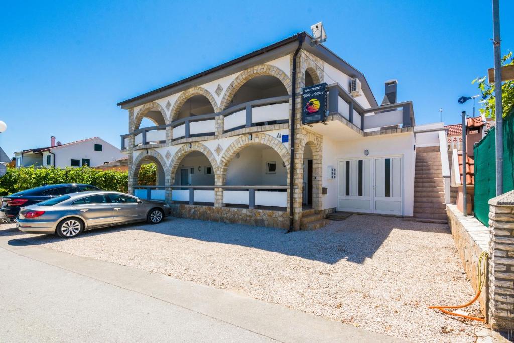 a house with a car parked in front of it at Apartments with parking space Vir - 18540 in Vir